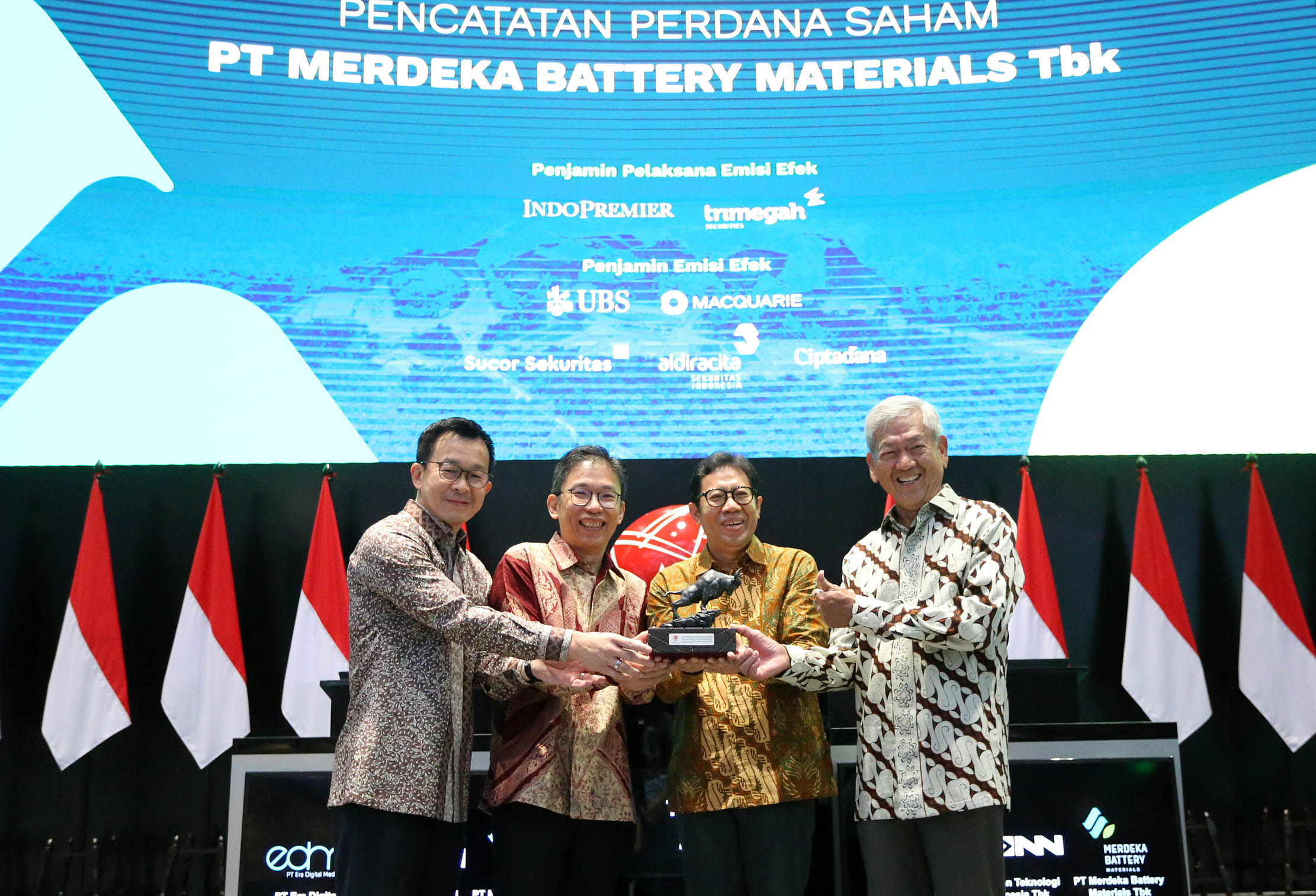 Presiden Direktur PT Merdeka Battery Materials Tbk (MBMA) Devin Ridwan (kedua kiri) didampingi pemegang saham perusahaan Edwin Soeryadjaya (kanan), dan Hardi Wijaya Liong (kiri) menyerahkan cenderamata kepada Direktur PT Bursa Efek Indonesia I Gede Nyoman Yetna (kedua kanan) setelah pencatatan perdana saham MBMA di Bursa Efek Indonesia pada Selasa, 18 April 2023. Foto : Panji Asmoro/TrenAsia