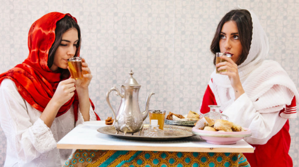 Ilustrasi dua wanita sedang menikmati hidangan lebaran