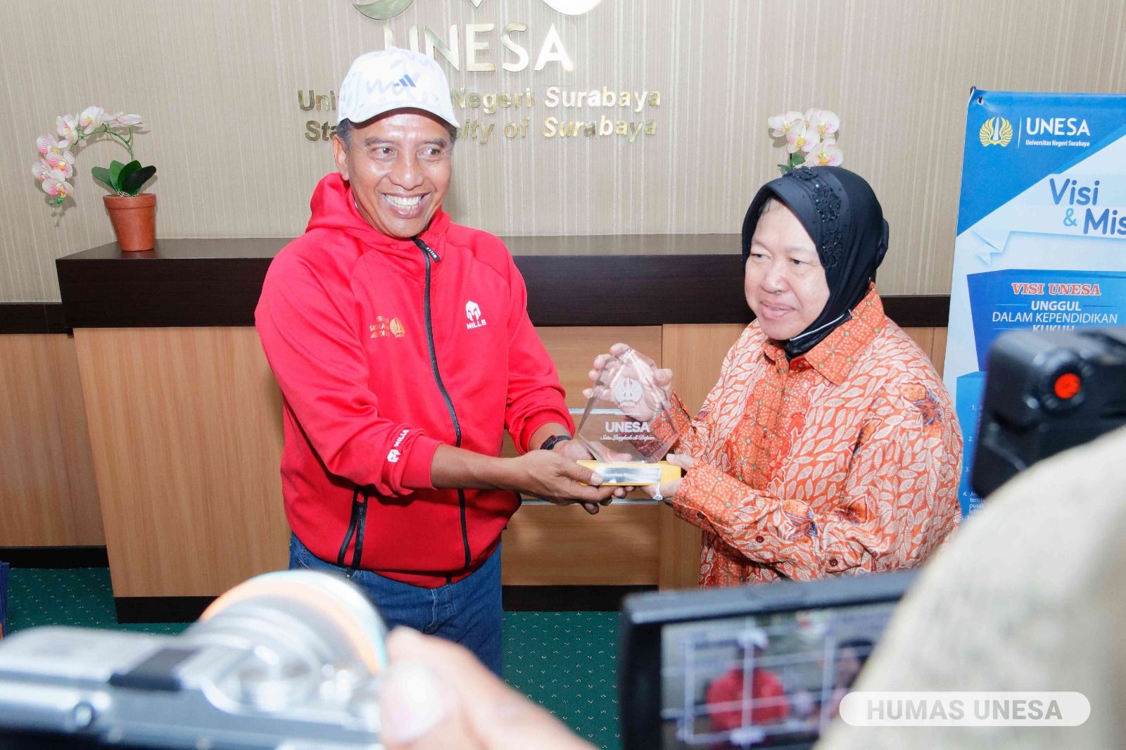 Mensos Tri Rismaharini menyerahkan salinan MoU kepada Rektor Unesa, Prof Nurhasan, Jumat (19/5/2023).
