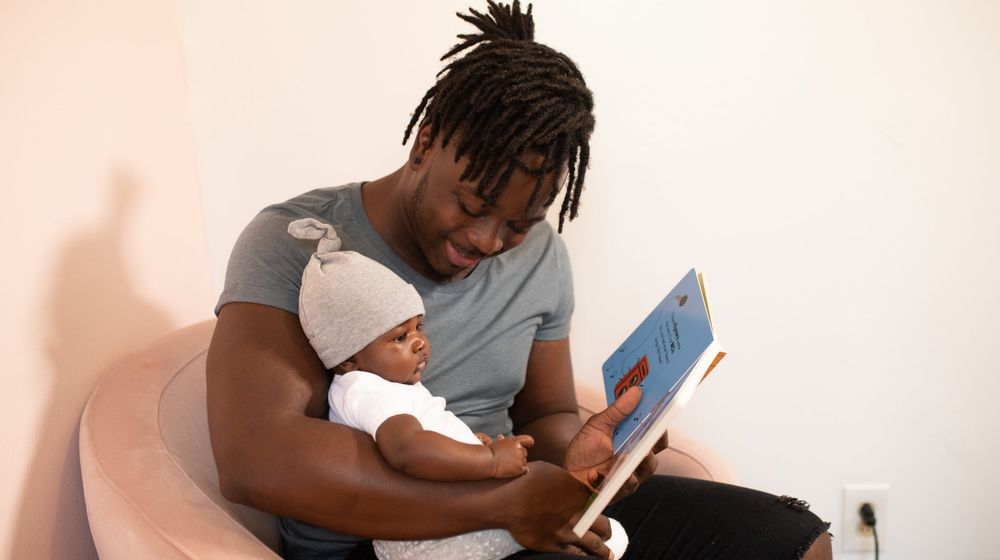 Photo by nappy: https://www.pexels.com/photo/a-father-reading-a-book-to-his-baby-3536643/