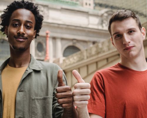 Photo by William  Fortunato : https://www.pexels.com/photo/positive-young-multiracial-guys-demonstrating-thumbs-up-sign-at-camera-6140715/