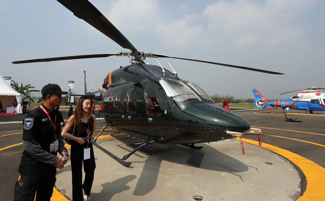 Pengunjung melihat helikopter yang dipamerkan di ajang Heli Expo Asia 2023 di Cengkareng Heliport Bandara Soekarno Hatta, Tangerang.Jumat 16 Juni 2023. Pameran yang berlangsung hingga Minggu (18/6) tersebut menghadirkan berbagai model helikopter serta menjadi ajang jual beli helikopter. Foto : Panji Asmoro/TrenAsia