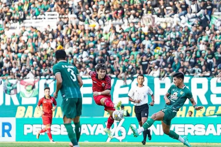 Dua pemain belakang Persebaya Surabaya mencoba menghadang tendangan pemain Persija di Stadion GBT.