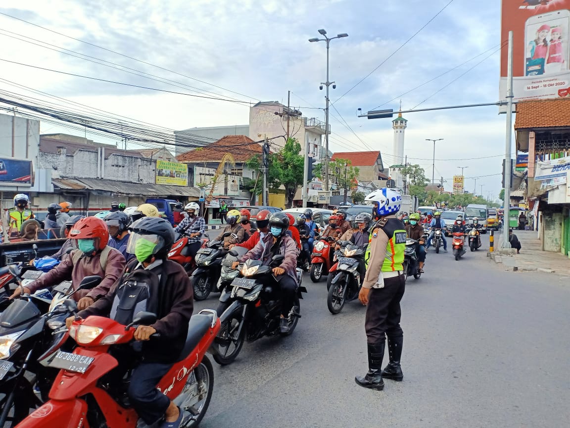 Petugas kepolisian mengatur pengguna jalan di kawasan Gedangan yang sangat padat.