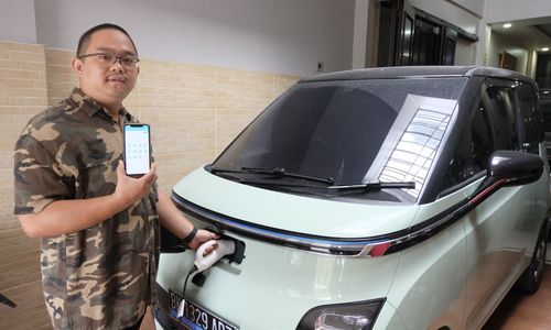 orang sedang mengisi daya mobil listrik.jpeg