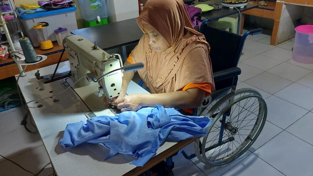 Penyandang disabilitas sedang diberi pelatihan menjahit. 