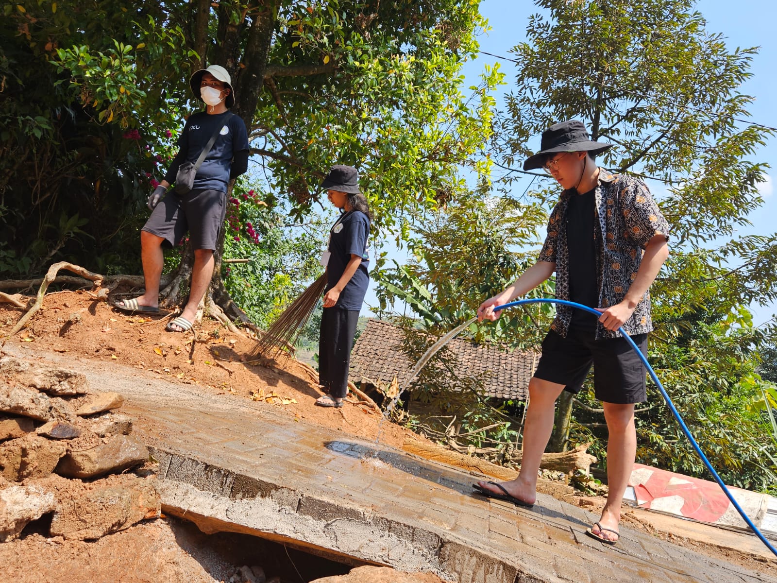 Mahasiswa Community Outreach Program (COP) yang digelar PCU memperbaiki jalan setapak dengan dipavingm di Kabupaten Mojokerto.