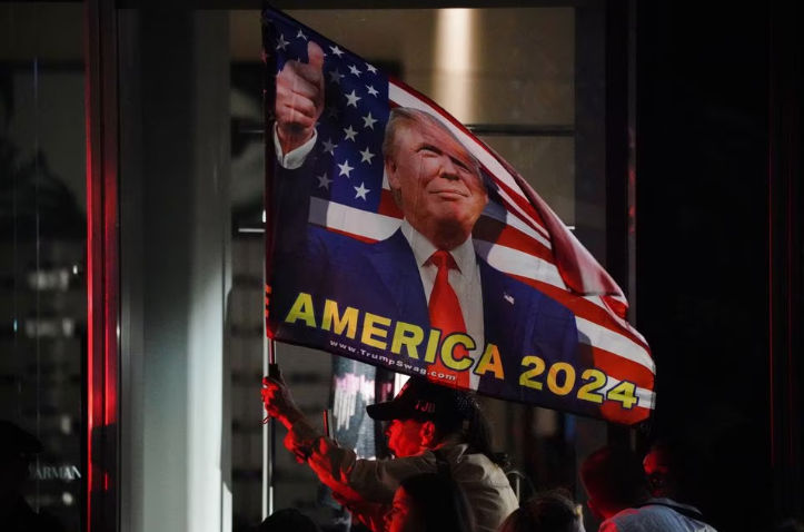 Pendukung Mantan Presiden AS Donald Trump Mengibarkan Bendera "Amerika 2024" 