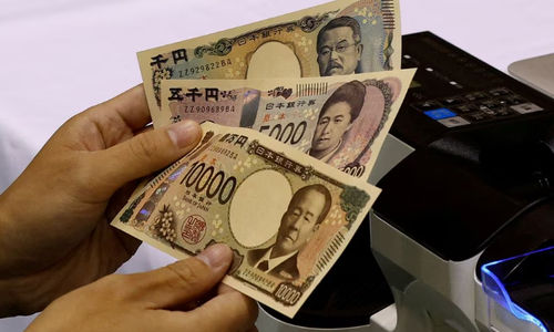 Seorang Pekerja Memegang Sampel Uang Kertas Yen Jepang