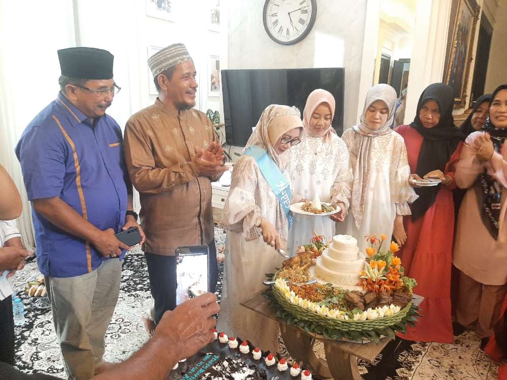 Hj Sri Asril didampingi suami memotong nasi tumpeng milad ke-51.