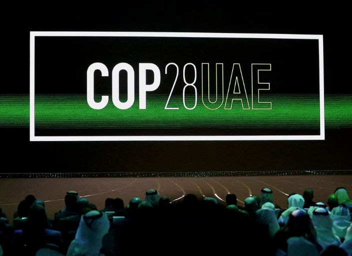 Logo 'Cop28 UAE' Ditampilkan di Layar Saat Upacara Pembukaan Abu Dhabi Sustainability Week (Reuters/Rula Rouhana)