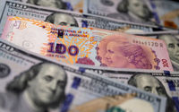 Uang Kertas Seratus Peso Argentina Berada di Atas Beberapa Uang Kertas Seratus Dolar AS