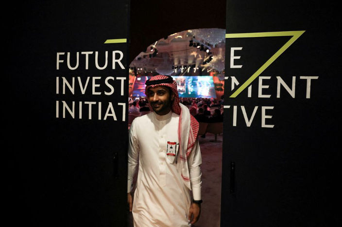Seorang Pria Saudi Terlihat di Kaca Cermin pada konferensi Future Investment Initiative (Reuters/Ahmed Yosri)