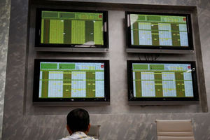 Seorang Investor Duduk di Depan Layar yang Menampilkan Informasi Saham di perusahaan Sekuritas, Hanoi