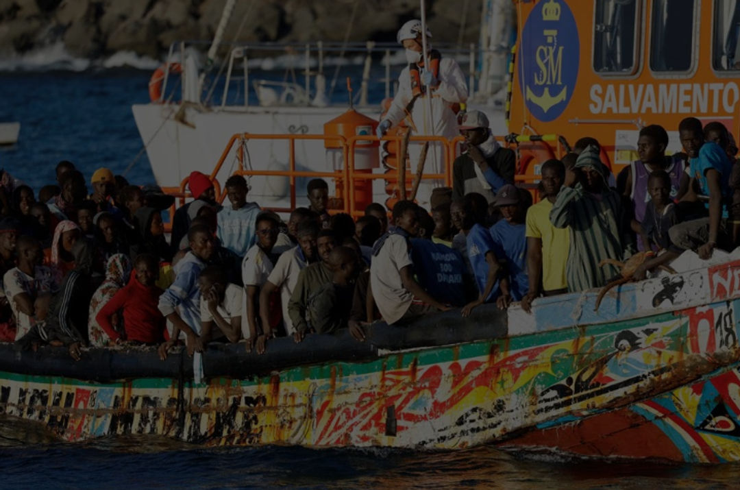 Sekelompok Migran dengan Perahu Kayu Ditarik oleh Kapal Penjaga Pantai Spanyol ke Pelabuhan Arguineguin (Reuters/Borja Suarez)