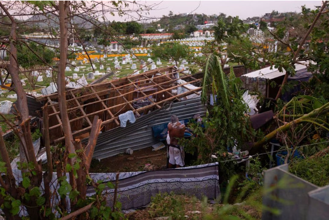 Seorang Pria Mandi di Samping Bangunan yang Rusak Akibat Badai Otis di dekat Acapulco (Reuters/Quetzalli Nicte-Ha)