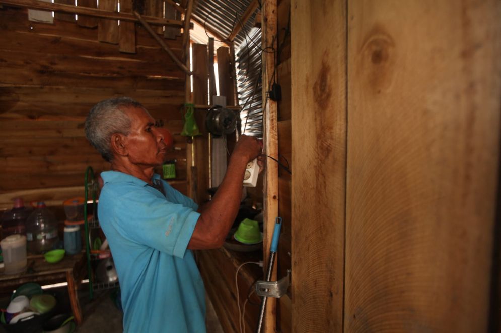 Sungkono sedang menyalakan lampu pemanfaatan panel surya yang merupakan program Desa Energi Berdikari (DEB) PT Pertamina Patra Niaga Regional Sumbagsel di desa Semambu, Ogan Ilir, Sumatera Selatan, Senin (23/10/2023). Program Desa Energi Berdikari (DEB) dengan pemanfaatan Energi Terbarukan dari sinar matahari tak hanya mendukung pertanian ramah lingkungan, tetapi juga digunakan untuk penerangan rumah warga disekitar dan rumah ternak.