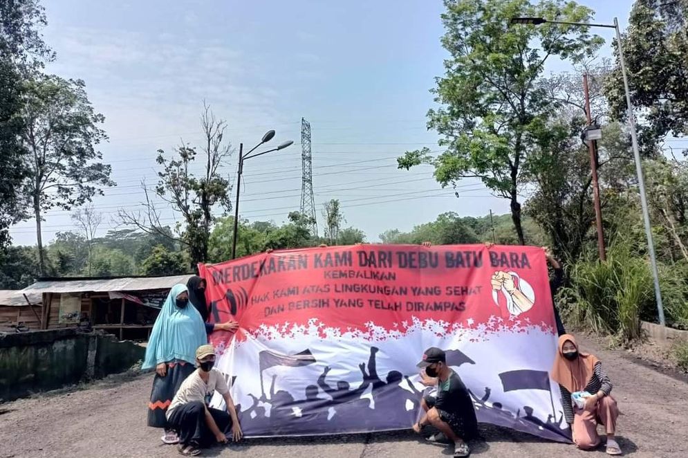 Sejumlah warga Desa Muara Maung memasang spanduk bertuliskan "Merdekakan  Kami dari Debu Batu Bara" saat perayaan hari Kemerdekaan RI ke-78 di tengah jalan menuju sejumlah perusahaan tambang di kawasan Merapi, Lahat, Sumatera Selatan