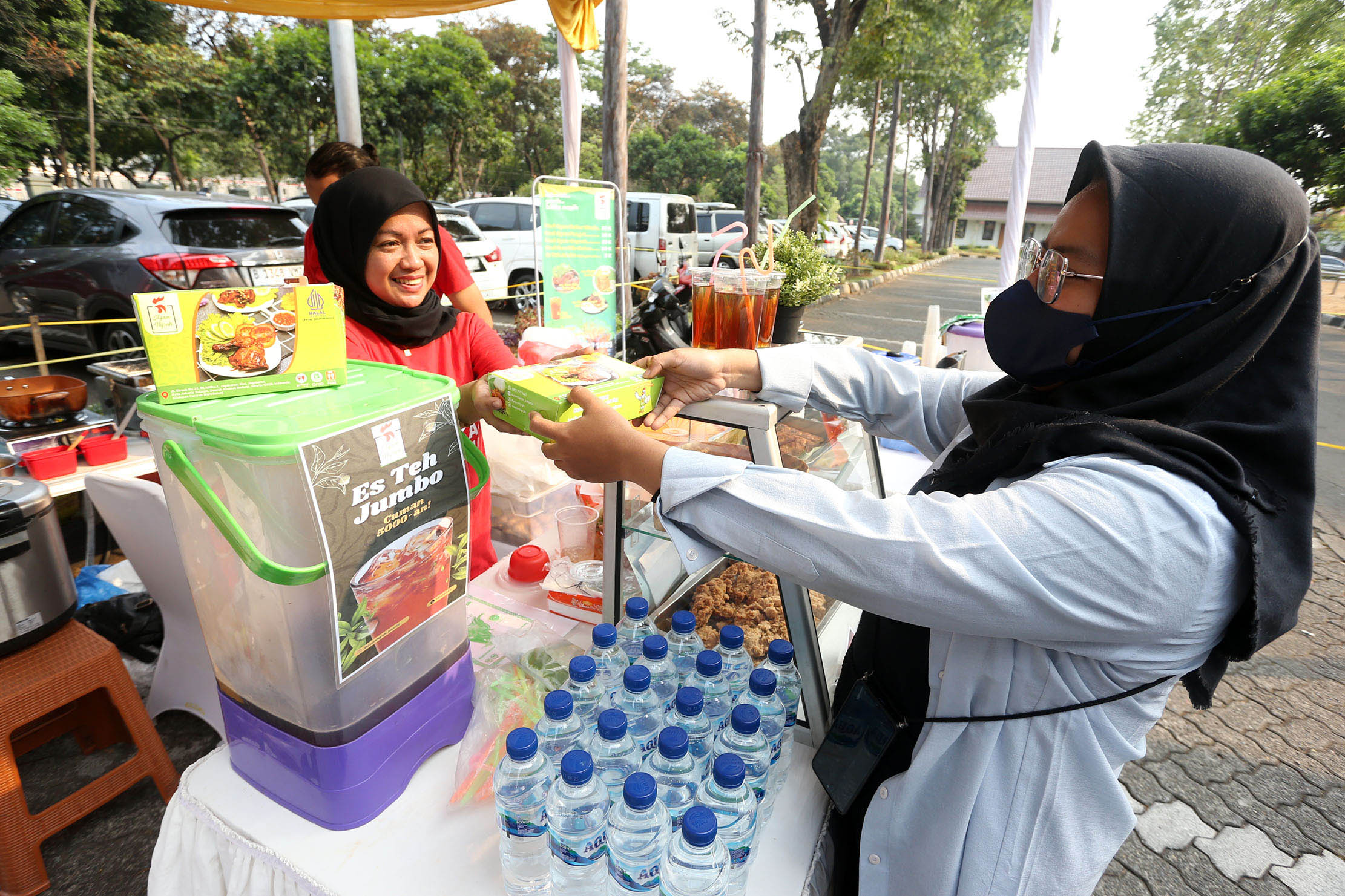 Erfianty Owner Ayam Bakar Madu Hijrah (kiri) Jagakarsa, salah satu UMKM yang mendapatkan manfaat pendanaan dari OVO Finansial melayani pelanggan saat bazaar di Universitas Pancasila, Jakarta, Senin 30 Oktober 2023. Foto : Panji Asmoro/TrenAsia