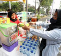 Erfianty Owner Ayam Bakar Madu Hijrah (kiri) Jagakarsa, salah satu UMKM yang mendapatkan manfaat pendanaan dari OVO Finansial melayani pelanggan saat bazaar di Universitas Pancasila, Jakarta, Senin 30 Oktober 2023. Foto : Panji Asmoro/TrenAsia