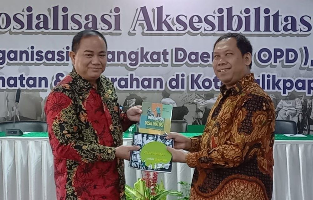 Direktur Eksekutif Sigab, Suharto Ph.D menyerahkan buku kota inklusif kepada Asisten II Pemkot Balikpapan, Andi Yusri Ramli ST, MT. (FOTO: FERRY CAHYANTI)