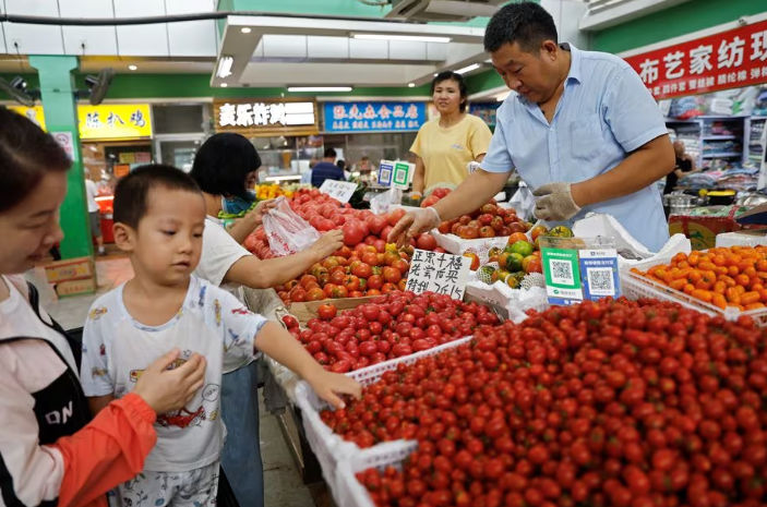 Pelanggan Memilih Tomat di Sebuah Kios di Dalam Pasar Pagi di Beijing (Reuters/Tingshu Wang)