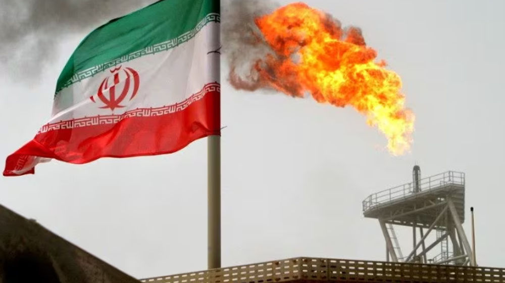 Sebuah Suar Gas di Anjungan Produksi Minyak Terlihat di Samping Bendera Iran
