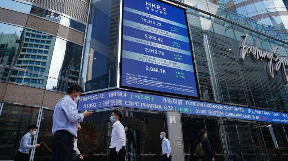 Orang-Orang Berjalan Melewati Layar yang Menampilkan Indeks Saham Hang Seng di Central district, Hong Kong