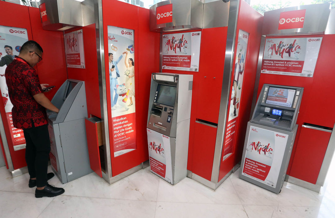 Nampak nasabah tengah melakukan aktifitas perbankan di mesin ATM dengan logo baru OCBC. 14 November 2023. Foto : Panji Asmoro/TrenAsia