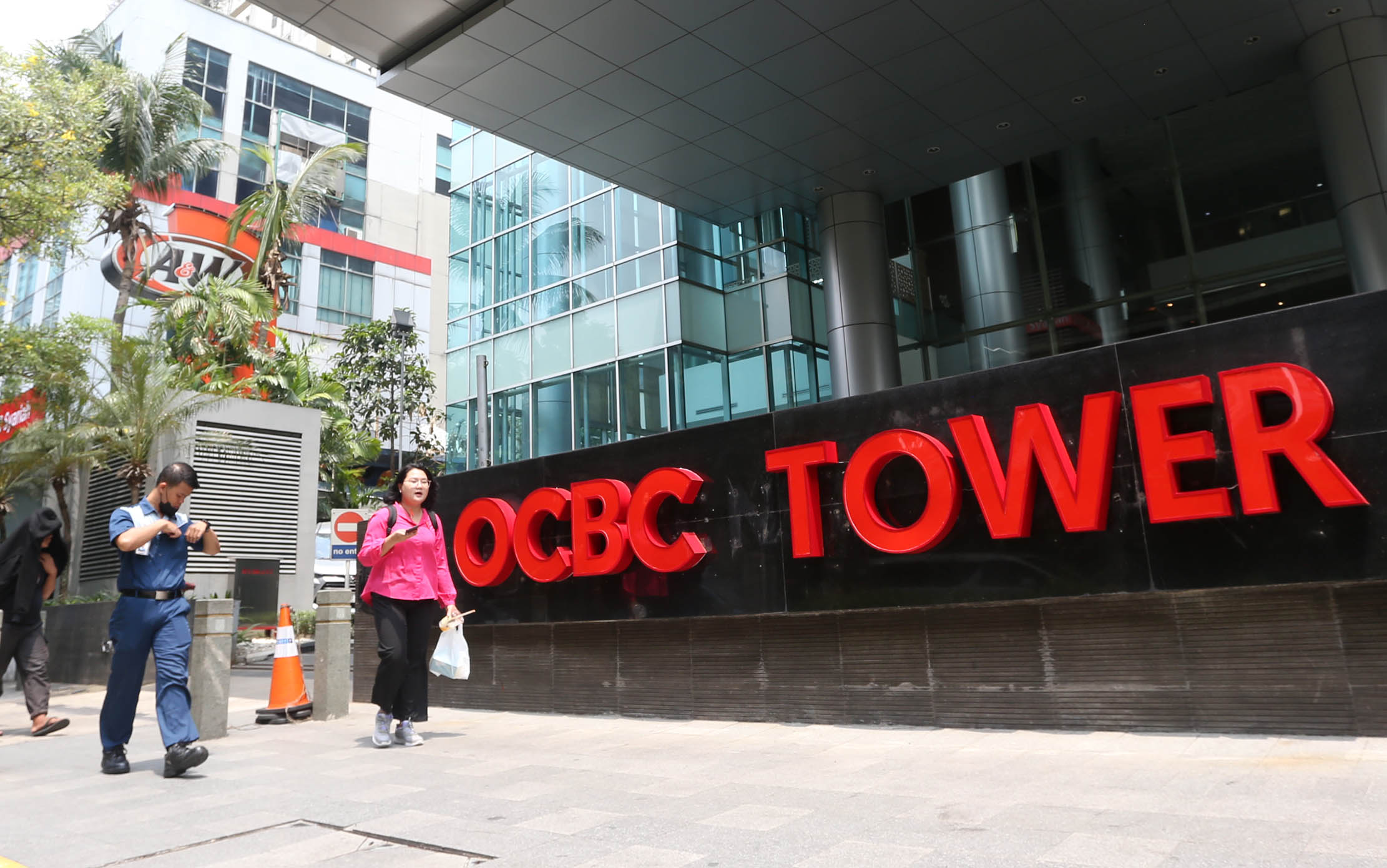 Nampak pejalan kaki melintas didepan logo baru OCBC di kawasan Kuningan Jakarta, 14 November 2023. Foto : Panji Asmoro/TrenAsia