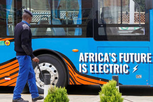 Seorang Petugas Polisi Berjalan di Samping Bus Angkutan Massal Listrik yang Dirakit oleh Ruang Produsen Kendaraan istrik di Terminal Green Park di Nairobi