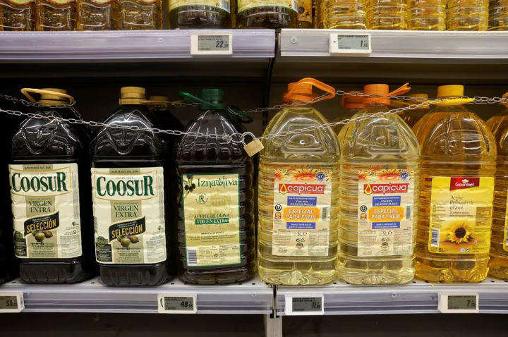Botol Minyak Zaitun dan Minyak Bunga Matahari Dipajang untuk Dijual, Dilindungi oleh Gembok dan Rantai untuk Mencegah Pencurian di Supermarket Tu Super Suma di Malaga (Reuters/Jon Nazca)