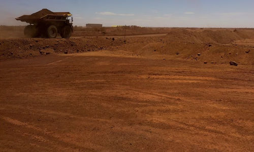 Kendaraan Otonom Melaju di Sepanjang Jalan Saat Mengumpulkan Bijih Besi di Tambang Fortescue Metals Group (FMG) Australia