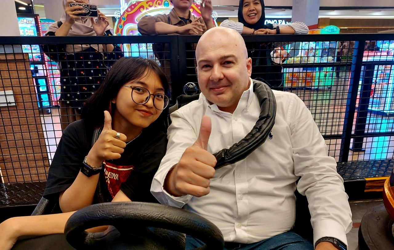 GM Operations Timezone Indonesia Lee Anthony Rance bersama salah seorang pengunjung bermain salah satu wahana di Time Zone Next Gen Experience di Centre Point Mall Medan