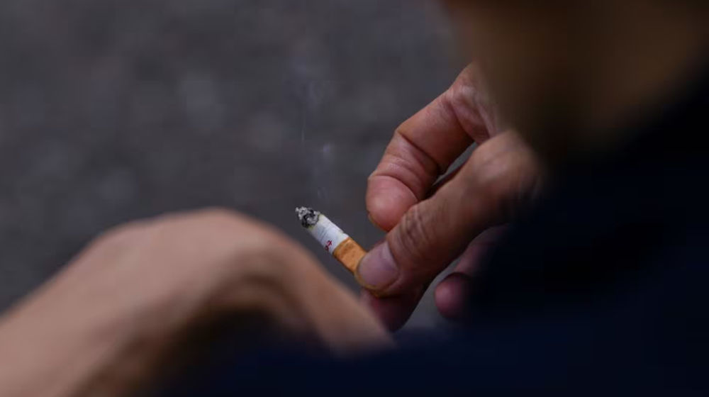 Seorang Pria Memegang Sebatang Rokok di Tangannya di London, Inggris