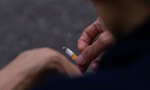 Seorang Pria Memegang Sebatang Rokok di Tangannya di London, Inggris