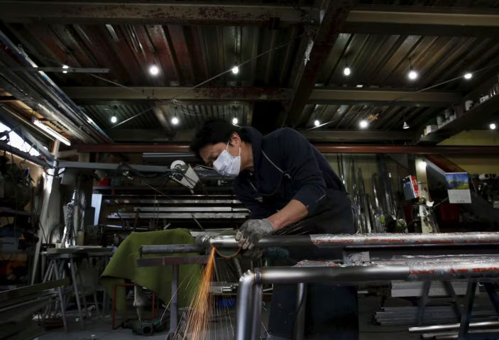 Seorang Insinyur Membuat Rel Lengan untuk Bangunan Tempat Tinggal di dalam Pabrik Pengolahan Logam di Kawasan Industri di Pusat Kota Tokyo (Reuters/Yuya Shino)
