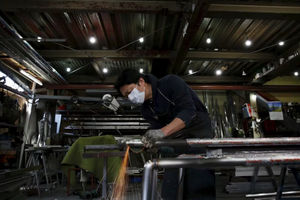 Seorang Insinyur Membuat Rel Lengan untuk Bangunan Tempat Tinggal di dalam Pabrik Pengolahan Logam di Kawasan Industri di Pusat Kota Tokyo