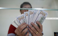 Staf Bank Menunjukkan Uang Kertas Seratus Dolar AS di Money Changer AYA Bank di Yangon