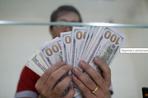 Staf Bank Menunjukkan Uang Kertas Seratus Dolar AS di Money Changer AYA Bank di Yangon
