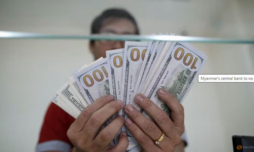 Staf Bank Menunjukkan Uang Kertas Seratus Dolar AS di Money Changer AYA Bank di Yangon