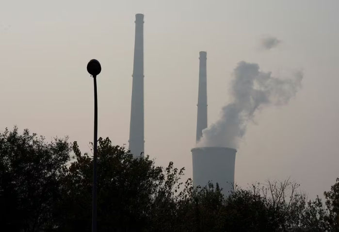 Menara Pendingin dan Cerobong Asap Terlihat di Pembangkit Listrik Tenaga Panas pada Hari yang Tercemar di Beijing (Reuters/Jason Lee)