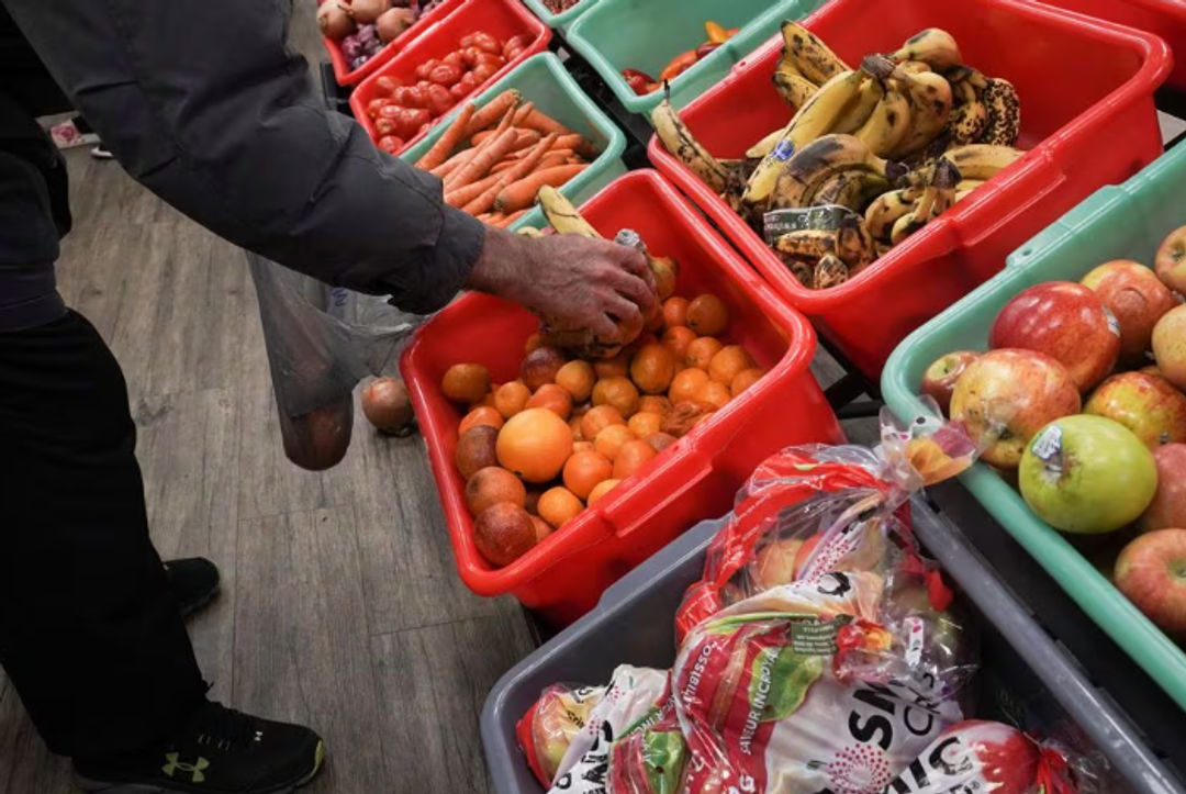 Seorang Anggota Komunitas Mengambil Sepotong Buah di Community Assistance Center food pantry, di Atlanta (Reuters/Megan Varner)