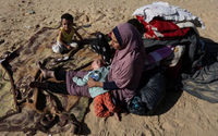 Seorang Wanita Duduk Bersama Anak-Anak di Luar, Sebagai Pengungsi Palestina