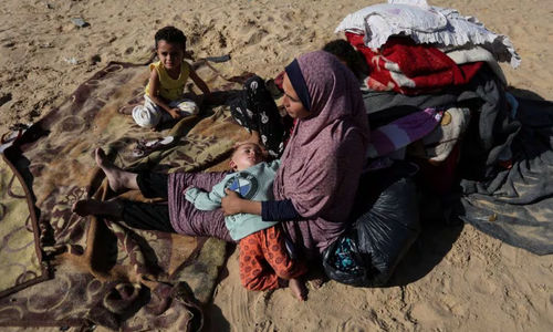 Seorang Wanita Duduk Bersama Anak-Anak di Luar, Sebagai Pengungsi Palestina