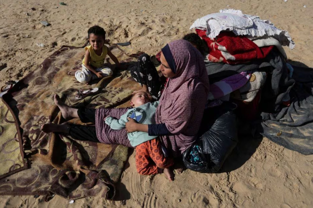 Seorang Wanita Duduk Bersama Anak-Anak di Luar, Sebagai Pengungsi Palestina