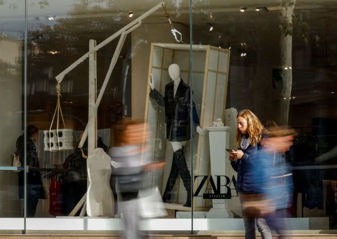 Orang-Orang Berjalan Melewati Etalase Toko Zara di Passeig de Gracia di Barcelona, Spanyol (Reuters/Albert Gea)