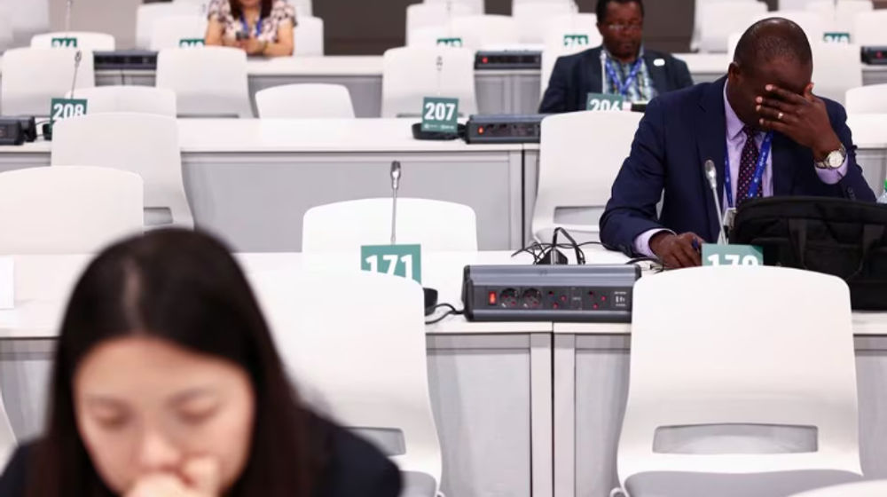 Seorang Delegasi Memberi Isyarat Saat Dia Bekerja di Sela-Sela Pertemuan Selama Tahap Akhir Konferensi Perubahan Iklim Perserikatan Bangsa-Bangsa COP28 di Dubai