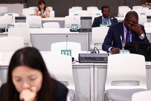 Seorang Delegasi Memberi Isyarat Saat Dia Bekerja di Sela-Sela Pertemuan Selama Tahap Akhir Konferensi Perubahan Iklim Perserikatan Bangsa-Bangsa COP28 di Dubai