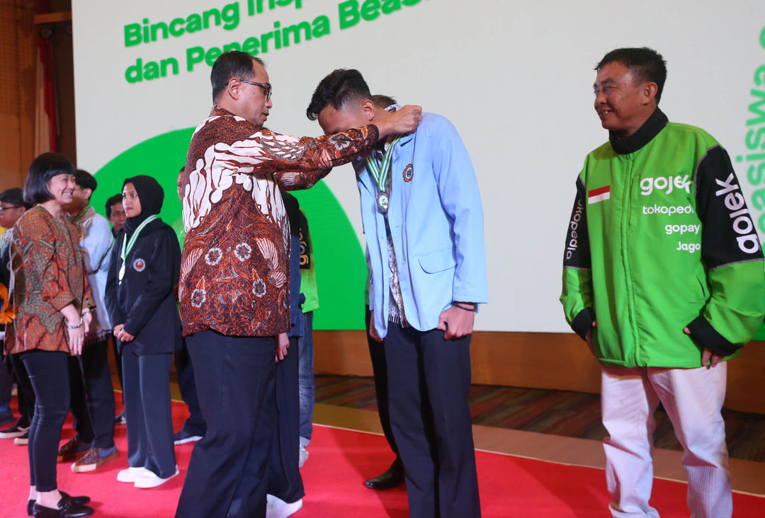 Menteri Perhubungan Republik Indonesia - Budi Karya Sumadi menyematkan medali kepada alumni penerima Beasiswa Gojek angkatan Pertama yang turut disaksikan oleh Direktur dan Presiden Unit Bisnis On-Demand Services Grup GoTo - Catherine Hindra Sutjahyo di Jakarta. 11 Desember 2023. Foto : Panji Asmoro/TrenAsia